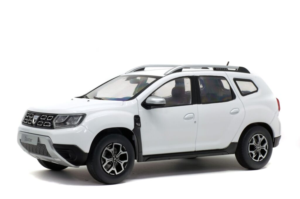 A white Dacia Duster SUV is parked on a white background.